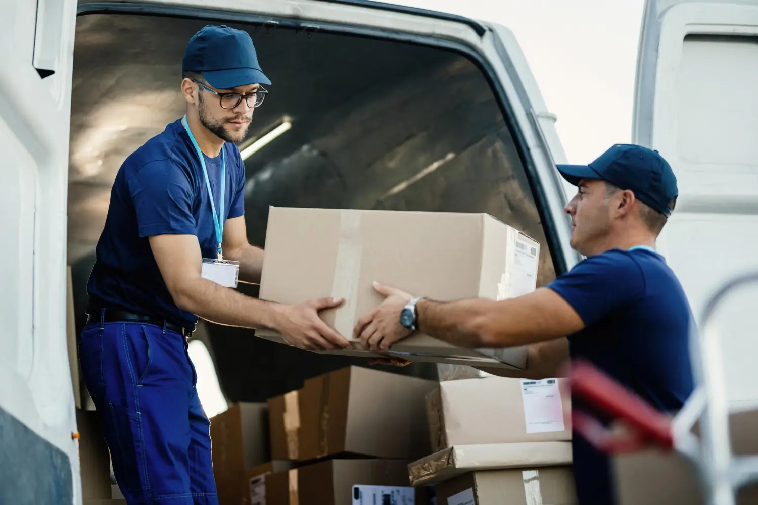 AMCO delivery team loading cardboard boxes into a van for a scheduled route